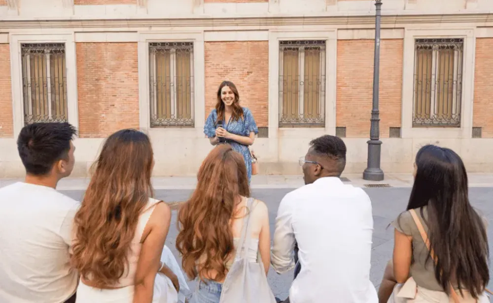 Smiling woman guide speaking in front of a group of friends